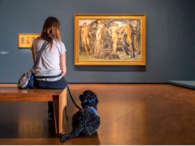 Girl sitting with support dog in gallery