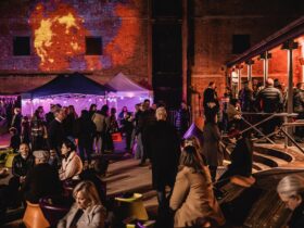 A vibrant, warmly lit courtyard at the Tasmanian Museum and Art Gallery with lots of people