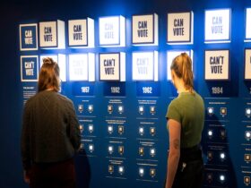 Museum visitors interacting with installation on blue wall within MoAD's Blueprint exhibition