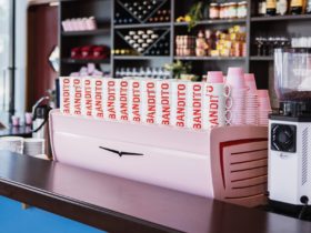 pink white eagle coffee machine with cups stacked together that say 'bandito'