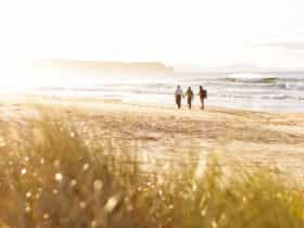 Couple walking along neck beach, Bruny Island