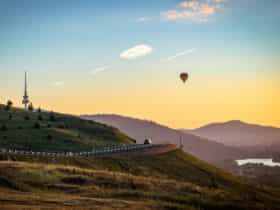 Hot air balloon over hills with view to the city centre