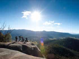 Small group of people looking out over magnificent views of the valley and mountain ranges