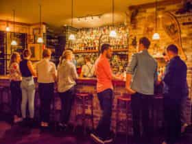 Young people lined up at the bar for cocktails