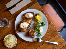 A plate of eggs on toast with pickles, hash browns and sauerkraut