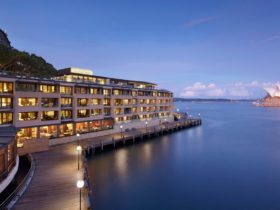 Hero landscape shot of Park Hyatt Sydney hotel under Harbour Bridge and across from the Opera House