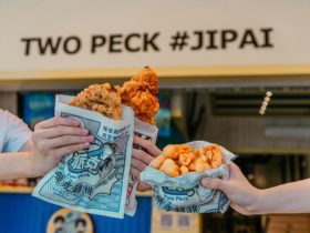 Three hands holding three food items from Two Peck Crispy Chicken