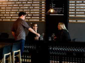 Two women enjoy glasses of wine indoors